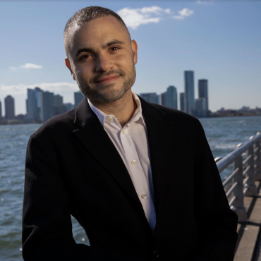 Thomas J. Lax smiling at the West Side pier in New York City