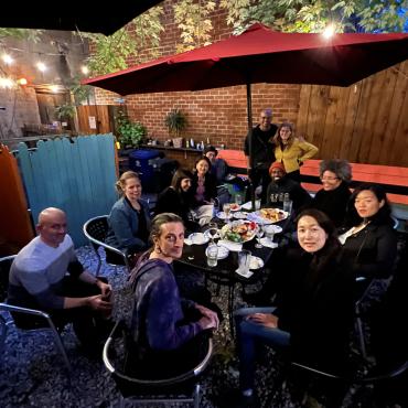 A group of artists seated around a patio table.